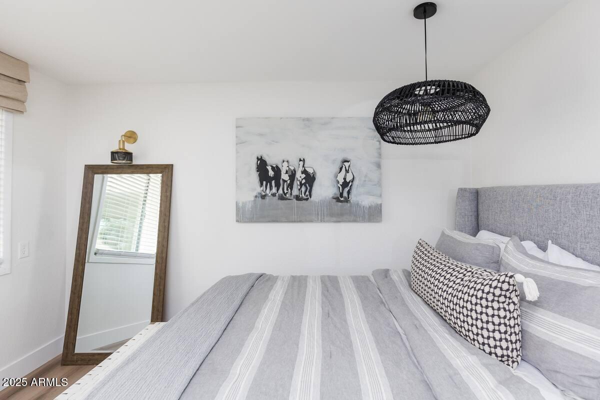 7625 East Camelback Road, Unit A252 Scottsdale, AZ 85251 - Photo 15 of 29 a bedroom with a bed and wooden floor