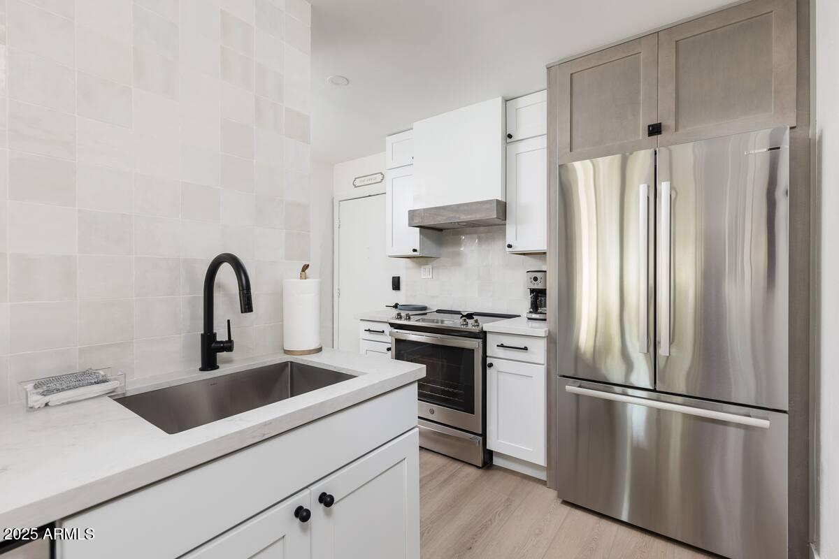7625 East Camelback Road, Unit A252 Scottsdale, AZ 85251 - Photo 7 of 29 a kitchen with stainless steel appliances a refrigerator sink and white cabinets
