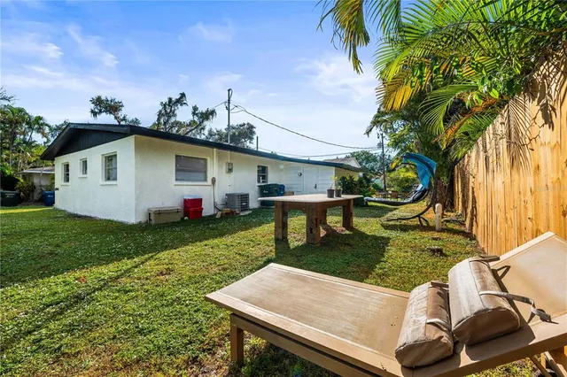 an aerial view of residential house with outdoor space and trees all around