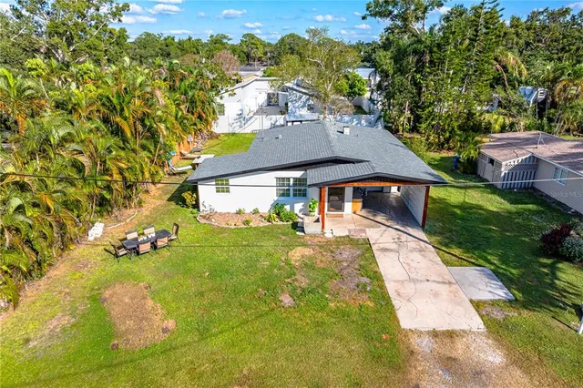 an aerial view of residential houses with outdoor space and trees