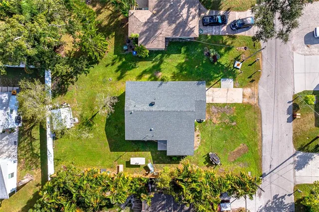 an aerial view of residential houses with outdoor space and trees