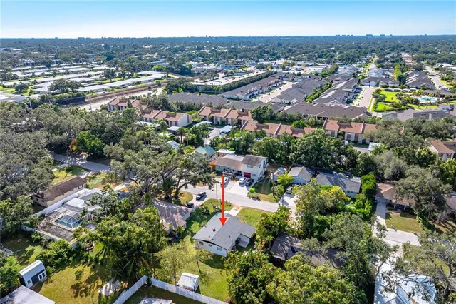 an aerial view of residential houses with outdoor space and trees