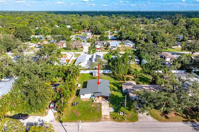 an aerial view of residential building with parking and yard