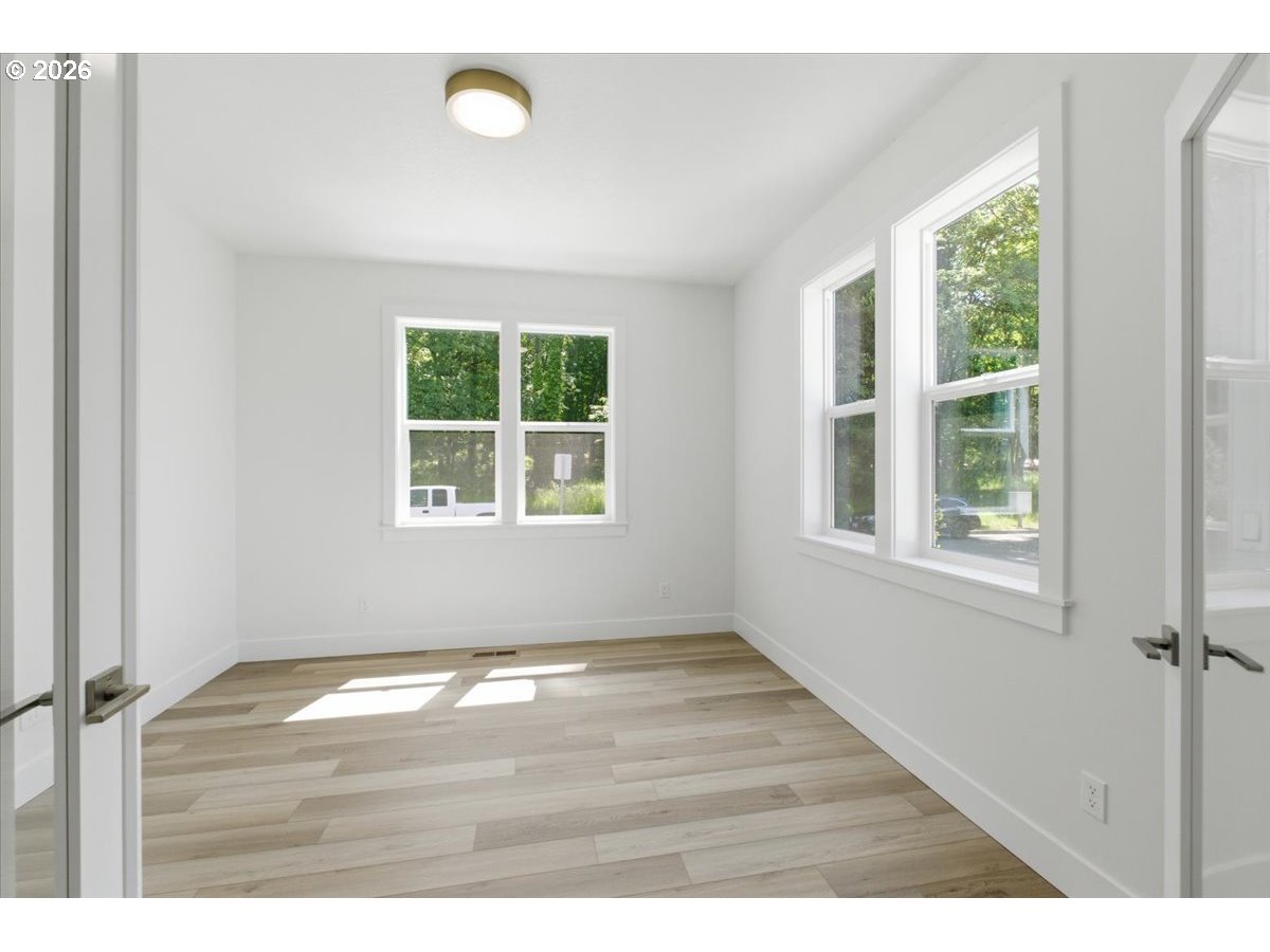 2147 Northeast Spitz Road Canby, OR 97013 - Photo 6 of 48 a view of an empty room with wooden floor and windows