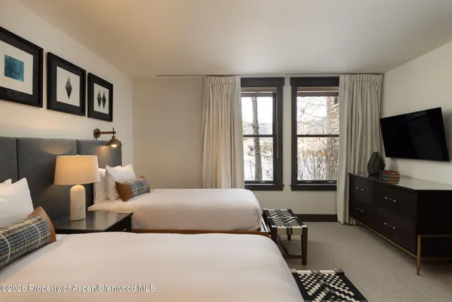 a bedroom with two beds and a flat screen tv