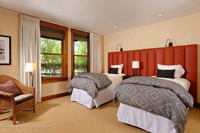 a spacious bedroom with two beds and large window