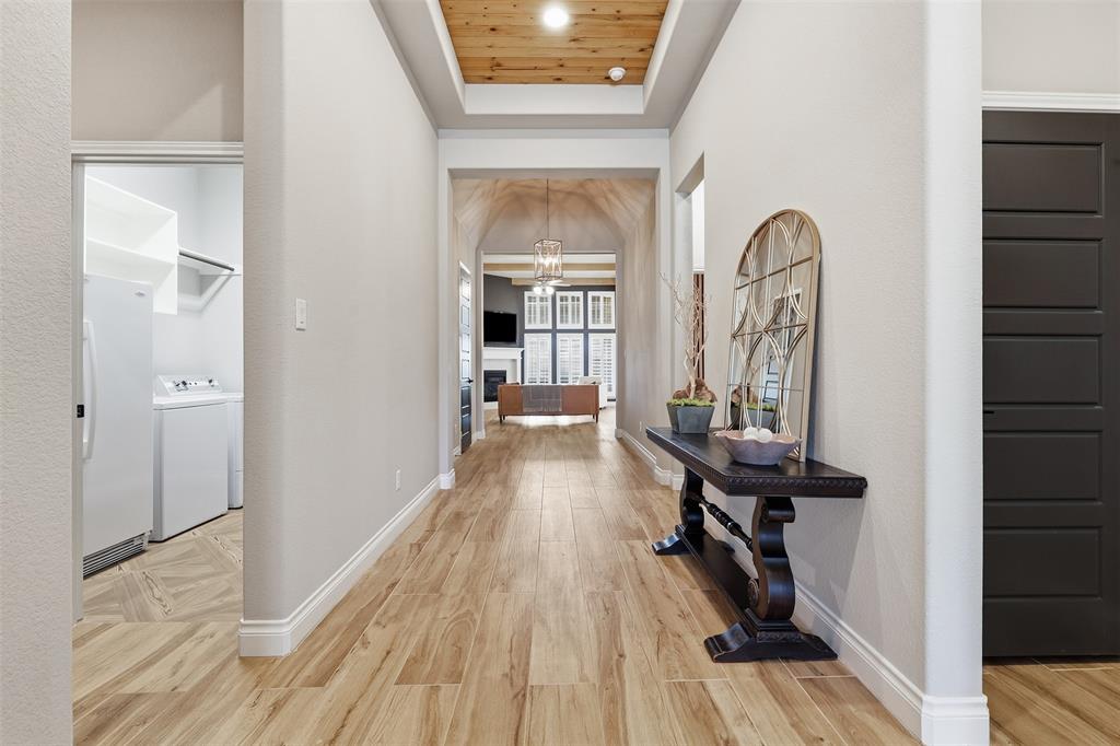 5640 Pradera Road Fort Worth, TX 76126 - Photo 4 of 35 Hallway featuring wood-finish flooring, a coffered ceiling with wood paneling, and an arched entry