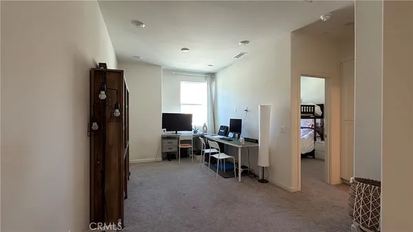 a view of a livingroom with entryway and workspace