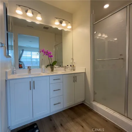 a bathroom with a double vanity sink a mirror and a shower