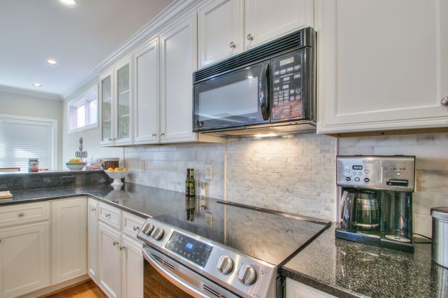 a kitchen with stainless steel appliances granite countertop a stove a microwave and sink