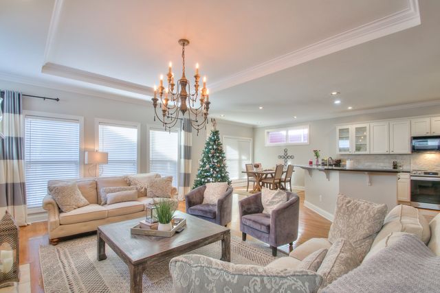 a living room with fireplace furniture and a chandelier