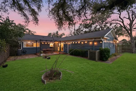 a view of a house with backyard and sitting area
