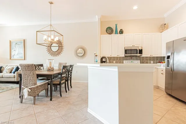 a kitchen with stainless steel appliances a table chairs and a refrigerator