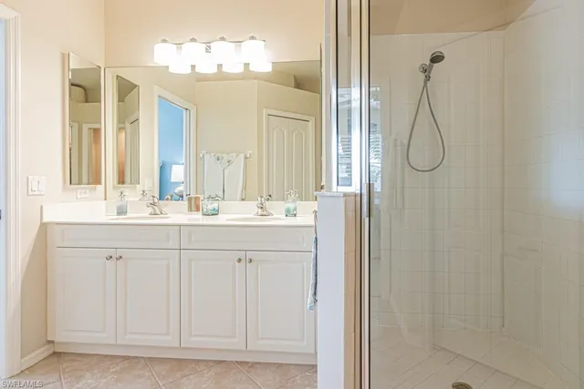 a bathroom with a double vanity sink mirror and shower