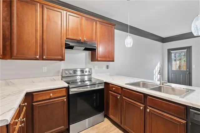 a kitchen with stainless steel appliances granite countertop a sink stove and cabinets