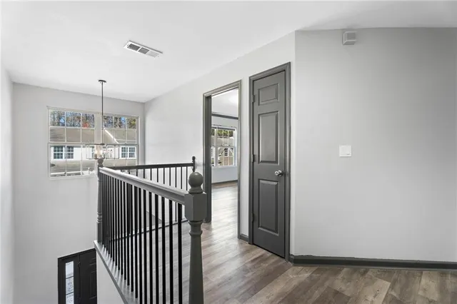 a view of a hallway with wooden floor and windows