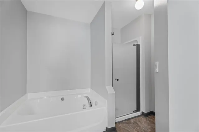 a white bath tub sitting next to a shower