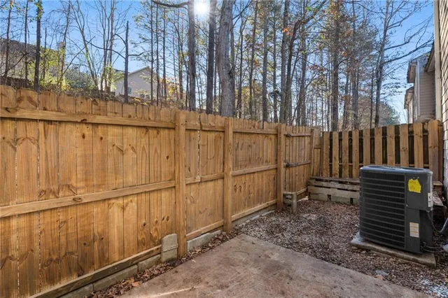 a backyard of a house with a fence and trees