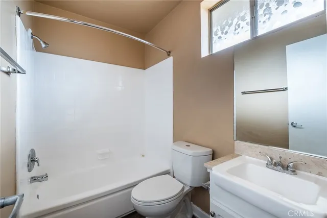 a white toilet sitting next to a bathroom sink