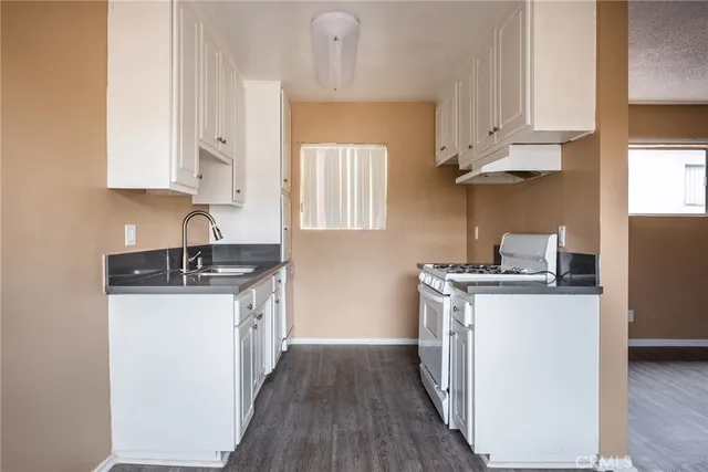 a kitchen with stainless steel appliances a sink stove and cabinets