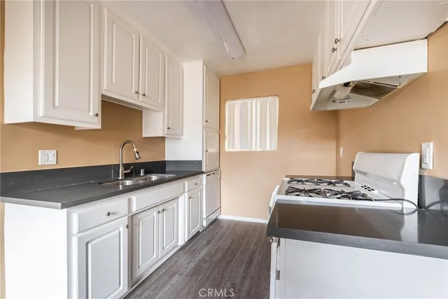 a kitchen with stainless steel appliances granite countertop a sink stove and white cabinets