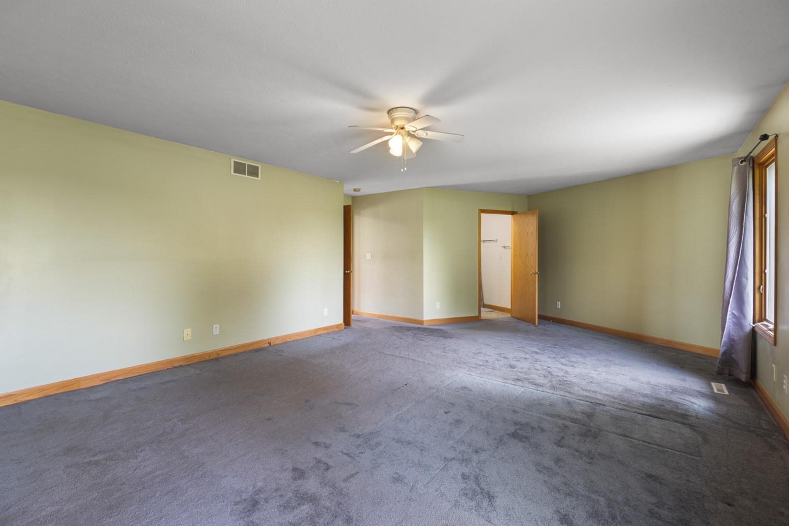 3433 Baxter Road Rockford, IL 61109 - Photo 34 of 43 an empty room with a ceiling fan and window