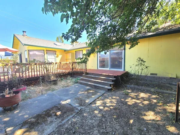 a view of a house with backyard and wooden fence