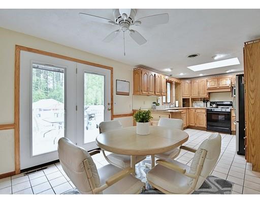 14 Bear Hill Road Billerica, MA 01821 - Photo 10 of 25 a open kitchen with stainless steel appliances granite countertop a stove a refrigerator a sink dishwasher a dining table and chairs with wooden floor