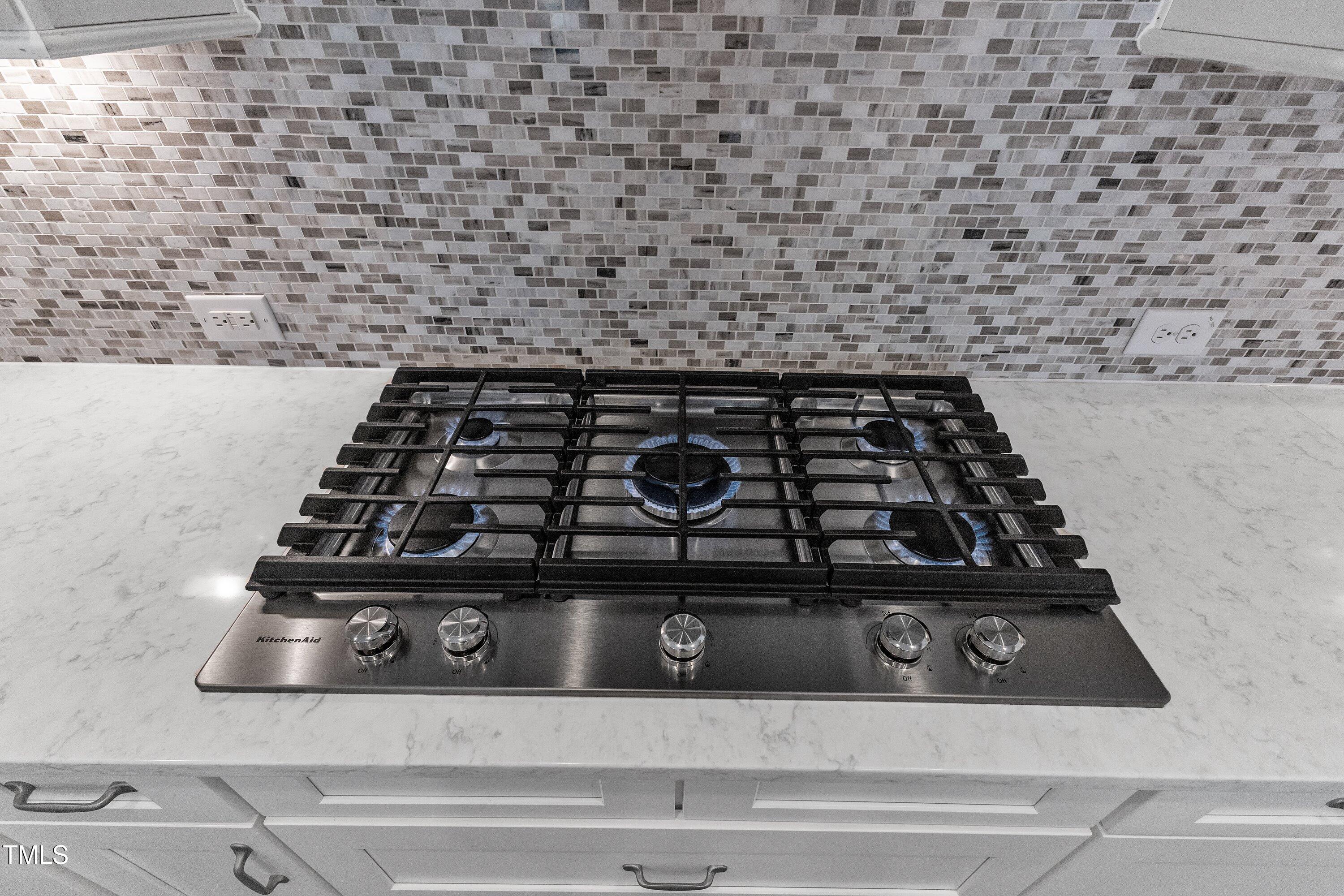 8121 Greys Landing Way Raleigh, NC 27615 - Photo 76 of 95 a close up of a stove top oven sitting on a granite counter top