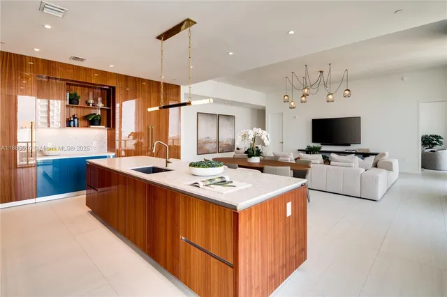 a dining room with stainless steel appliances kitchen island granite countertop a table chairs and a refrigerator