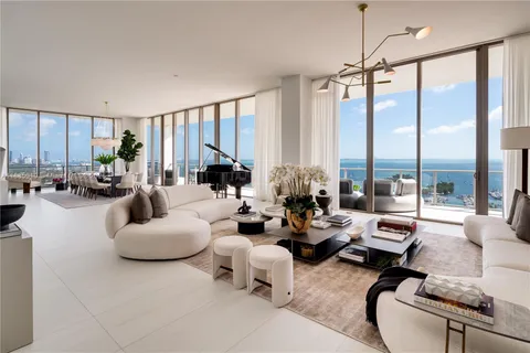 a living room with furniture fireplace and large windows