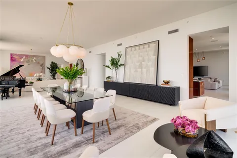 a large kitchen with stainless steel appliances a stove and a flat screen tv