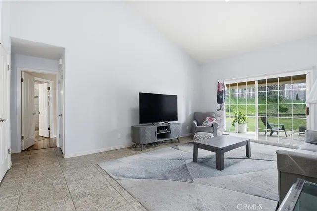 a dining room with furniture a rug and a floor to ceiling window