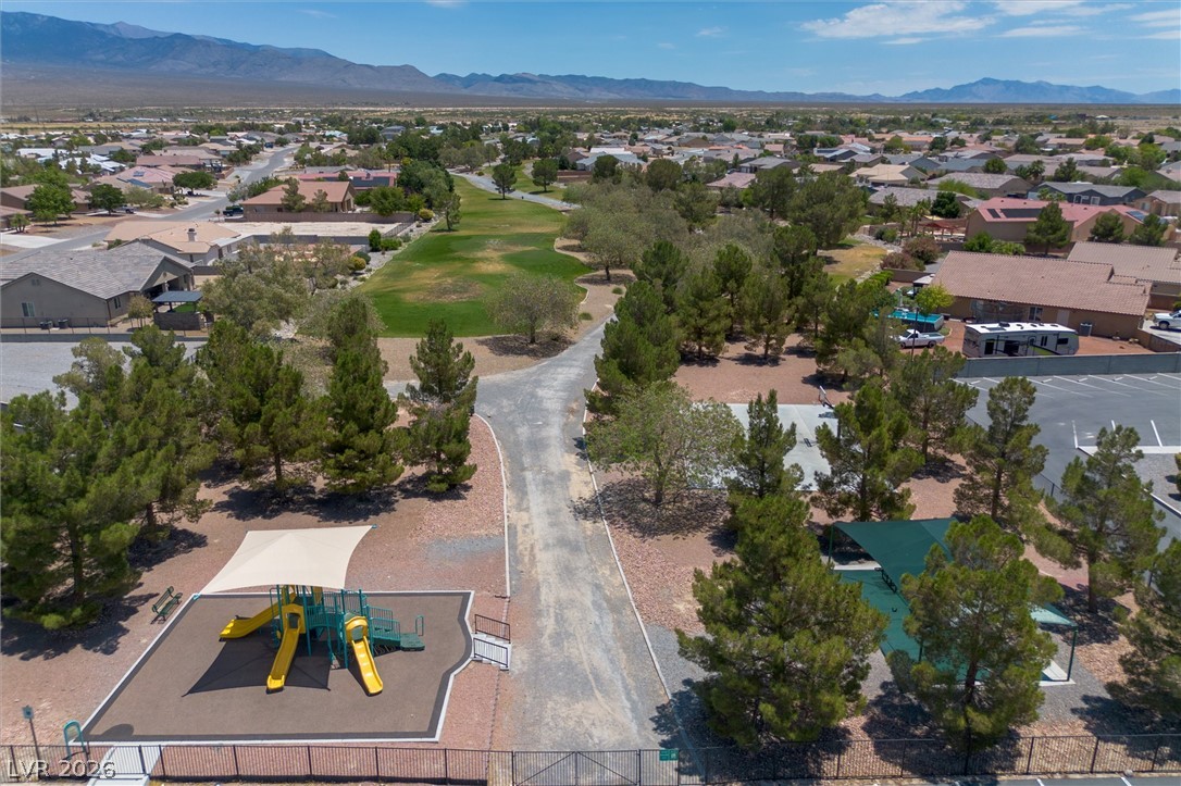 6720 Stubblefield Drive Pahrump, NV 89061 - Photo 41 of 51 An aerial perspective reveals a vibrant community playground and green spaces nestled against a distant mountain range.
