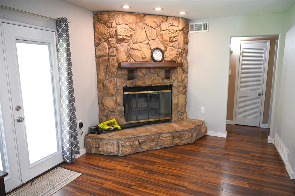 1352 Simpson Drive Hurst, TX 76053 - Photo 34 of 40 Corner stone fireplace with a wood mantel, recessed lighting, and wood-finish flooring