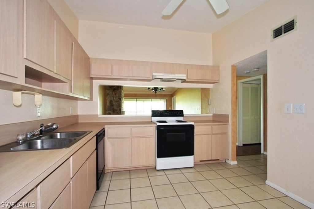 16740 Partridge Place Road, Unit 204 Fort Myers, FL 33908 - Photo 11 of 25 a kitchen with stainless steel appliances granite countertop a sink and a stove