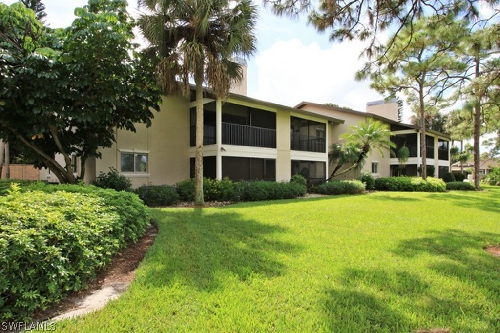 16740 Partridge Place Road, Unit 204 Fort Myers, FL 33908 - Photo 4 of 25 a front view of a house with a yard and trees