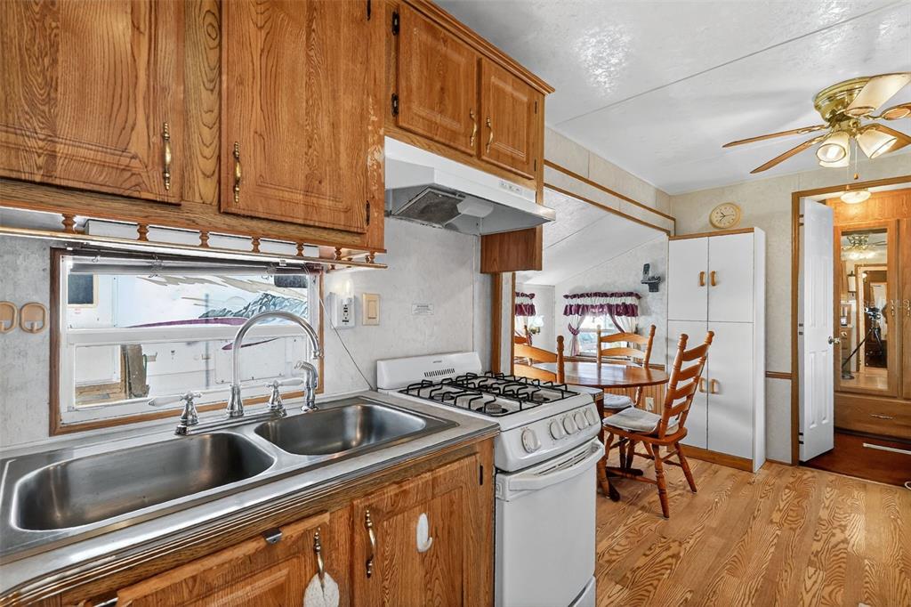 11324 Goldfinch Way Leesburg, FL 34788 - Photo 13 of 20 a kitchen with stainless steel appliances a sink a stove and a wooden floors