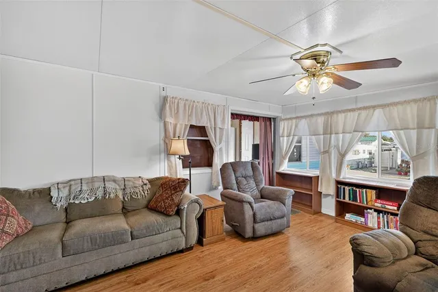 a living room with furniture a ceiling fan and a rug
