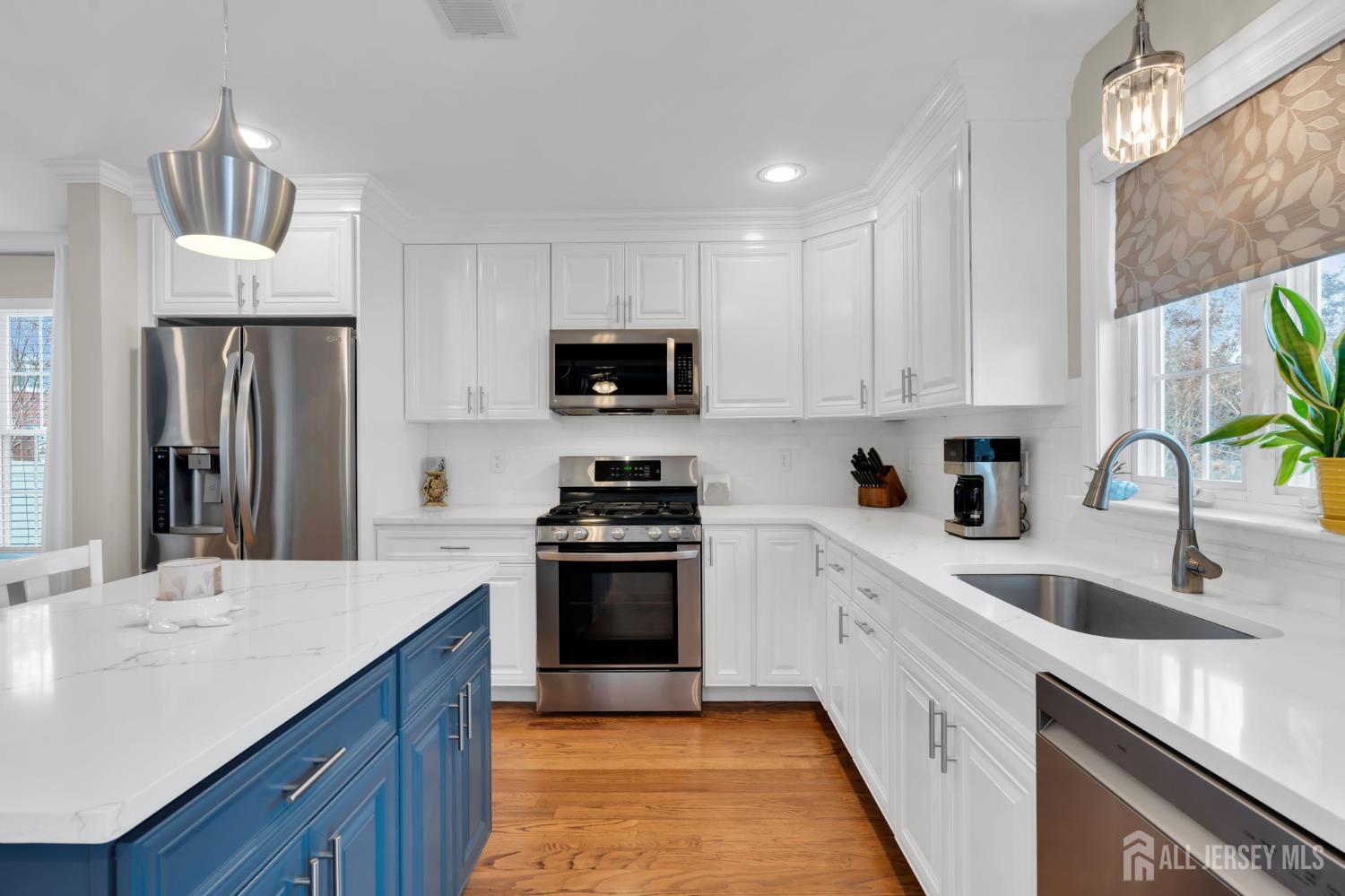 3 Harrison Avenue Aberdeen, NJ 07747 - Photo 12 of 46 a kitchen with kitchen island granite countertop a sink stainless steel appliances and white cabinets