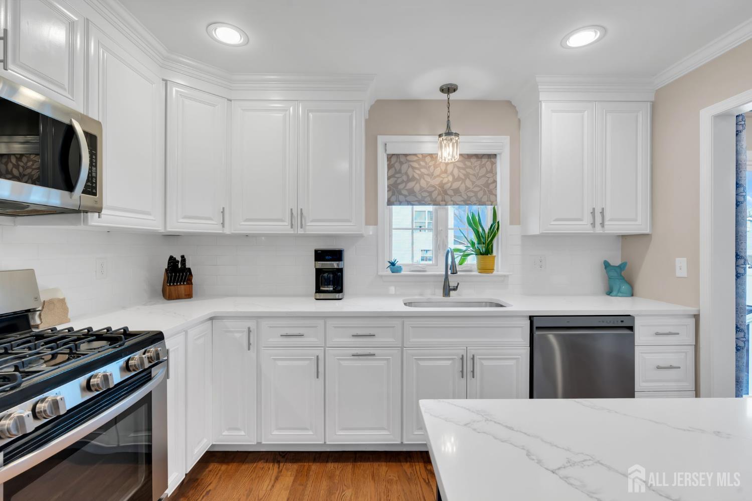3 Harrison Avenue Aberdeen, NJ 07747 - Photo 16 of 46 a kitchen with stainless steel appliances white cabinets and a stove top oven