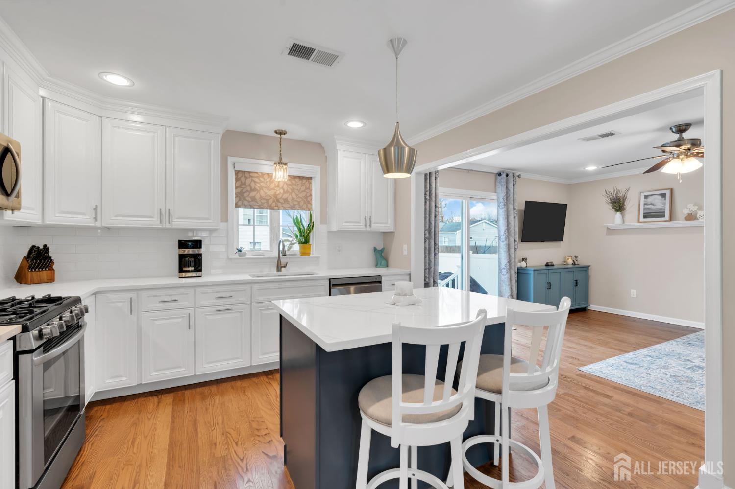 3 Harrison Avenue Aberdeen, NJ 07747 - Photo 17 of 46 a kitchen with stainless steel appliances kitchen island granite countertop a stove a sink a dining table and chairs