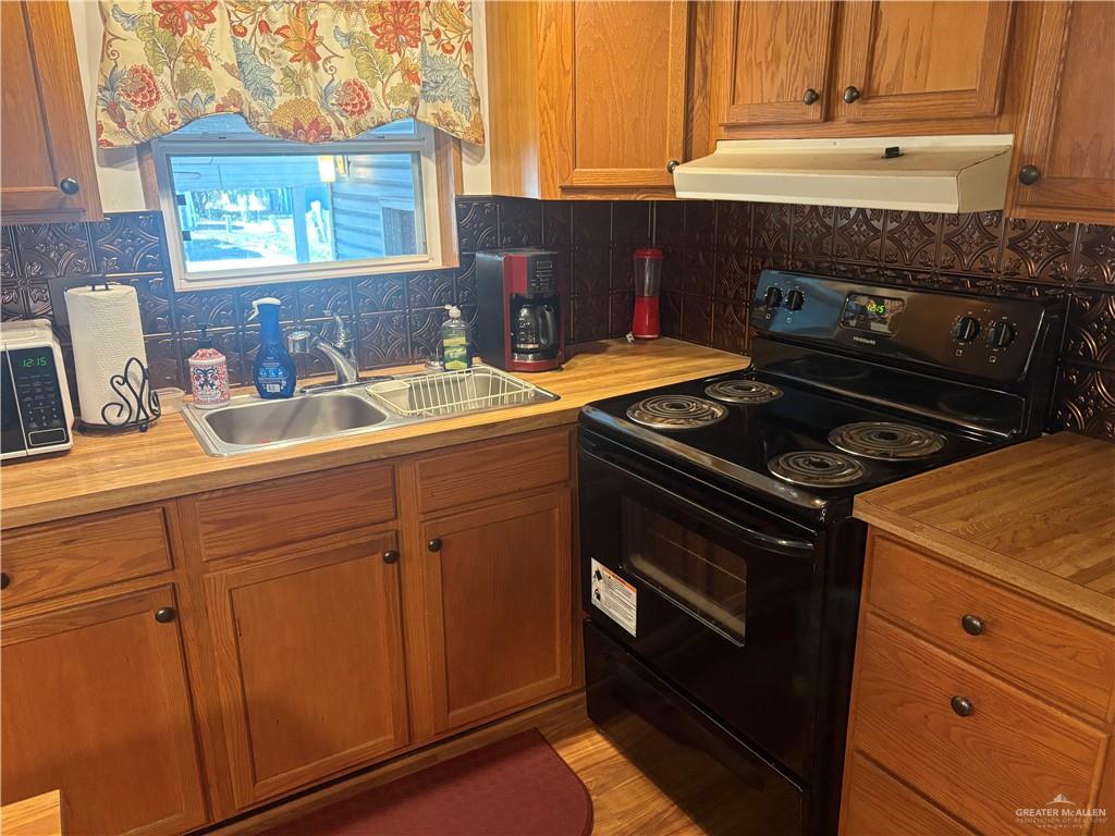310 Randal Drive, Unit H12 Mission, TX 78572 - Photo 8 of 36 a kitchen with granite countertop white cabinets and black appliances