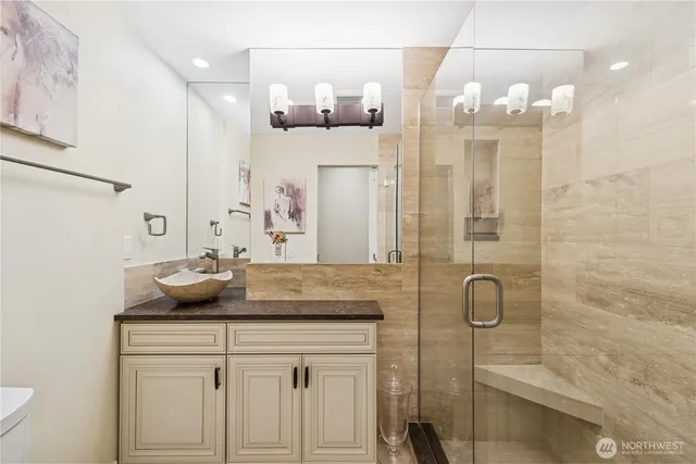 a bathroom with a granite countertop sink a mirror and shower