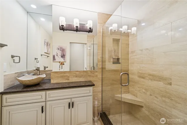 a bathroom with a granite countertop sink a mirror and shower