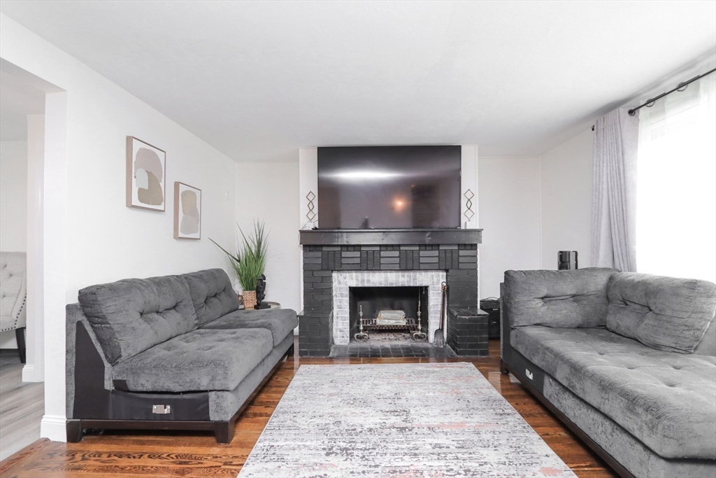 143 Redlands Street Springfield, MA 01104 - Photo 14 of 38 a living room with furniture a flat screen tv and a fireplace