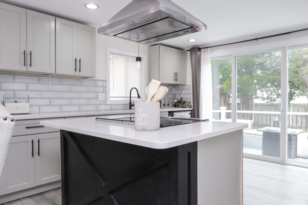 143 Redlands Street Springfield, MA 01104 - Photo 2 of 38 a kitchen with kitchen island a sink and a stove top oven