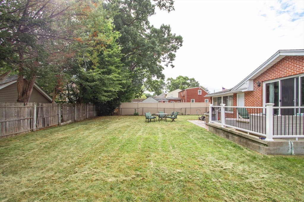 143 Redlands Street Springfield, MA 01104 - Photo 8 of 38 a backyard of a house with wooden fence and large trees