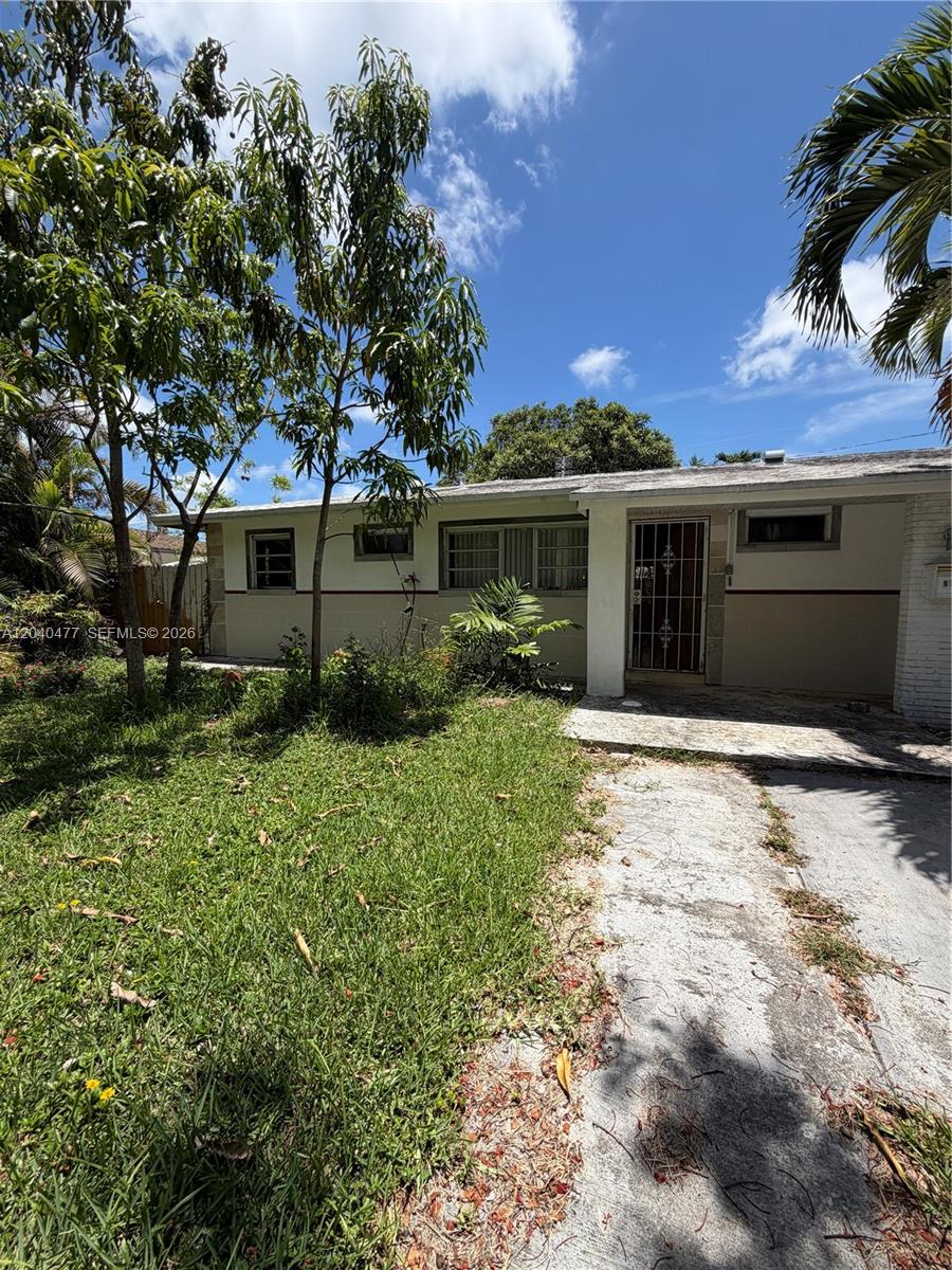 9110 Southwest 44th Street Miami, FL 33165 - Photo 3 of 18 a front view of a house with a yard and garage
