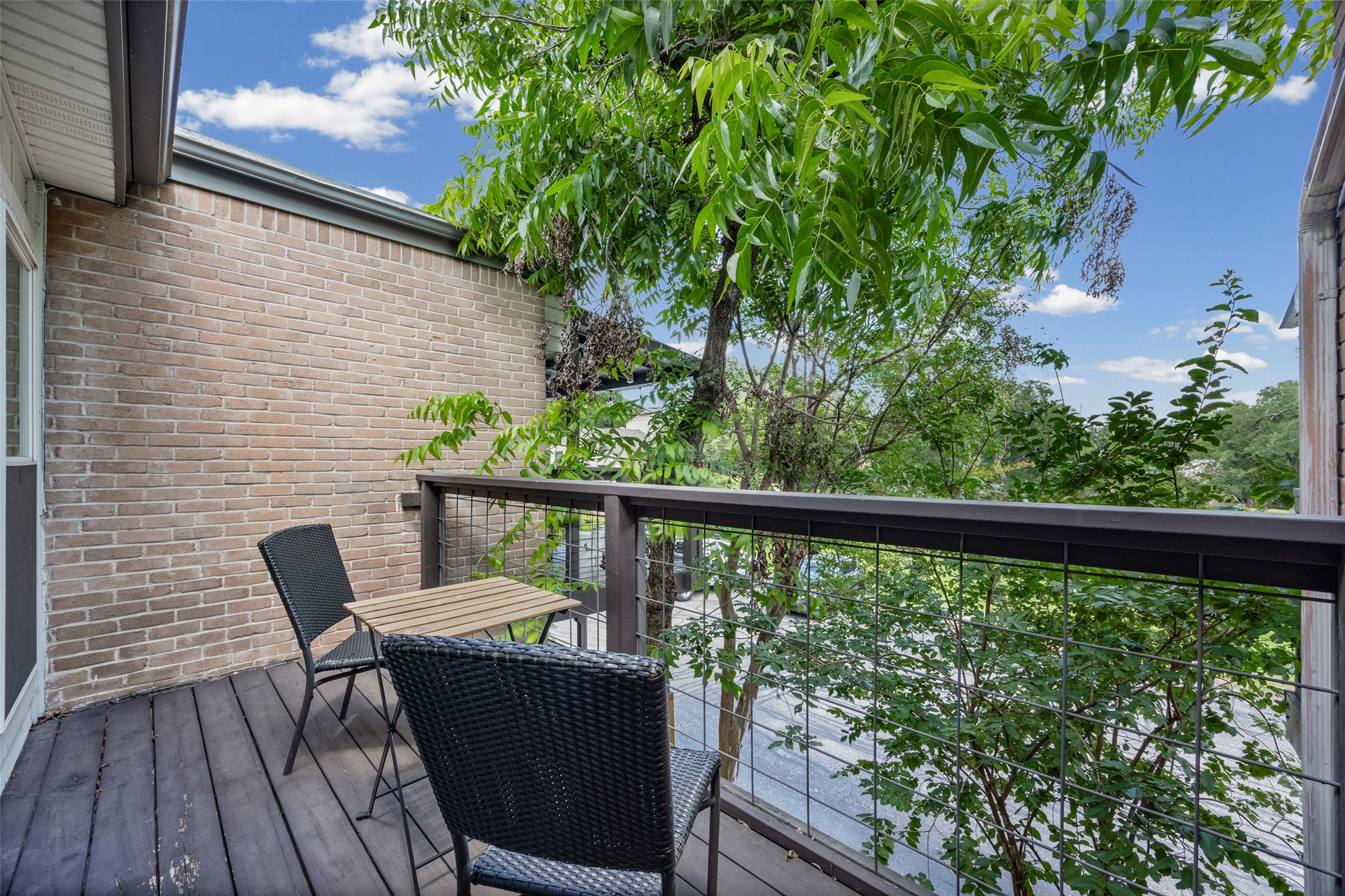 3809 Menchaca Road, Unit C Austin, TX 78704 - Photo 19 of 28 A tranquil private patio with wooden decking offers verdant tree-top views and a brick exterior.